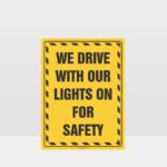 We Drive With Our Lights On For Safety Sign